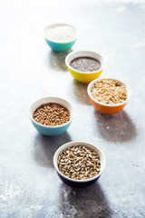 Variaty of raw cereals  on  bowls, top view flat lay,lentils, bulgur and quinoa, hemp seed,sunflower seeds ,brown rice, rice, healthy food concept , clean eating and detox concept.