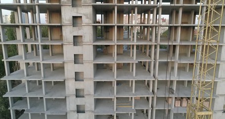 Aerial view of high rise residential complex under construction. Construction of apartment building in green zone. Multi-storey modern residential complex under construction