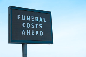 Advertising billboard with text FUNERAL COSTS AHEAD outdoors