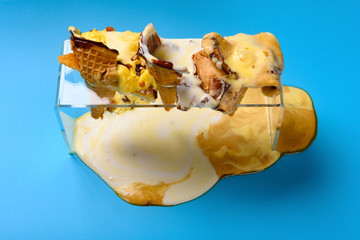 high angle view three pcs melted ice cream cones on blue background
