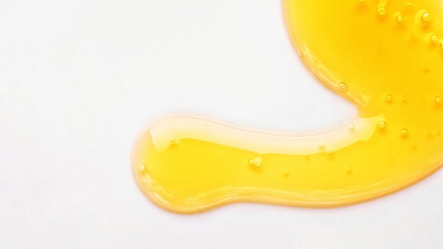 Yellow Serum Or Olive Oil Drop Texture Isolated On White Background, Transparent Bubble Gel Cosmetic Sample. Golden Liquid Acid Cream Swatch Or Honey Drip Close Up Skin Cosmetic Lotion Macro Top View