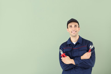 Male car mechanic on color background