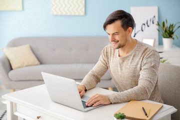 Handsome man working on laptop at home
