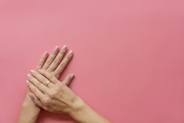 Stylish trendy female pink manicure. Beautiful young woman hands on pink pastel background with place for text. Minimal creative concept. Flat lay, top view, mock up, copy space, template