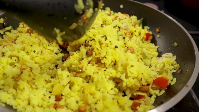 Top view of fresh Indian breakfast, Preparing Poha with veggies and ingredients in cooking pan.