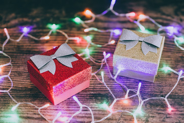 Christmas present box with bow and glitters surrounded by fairy lights