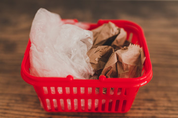 groceries shopping basket with both plastic and paper bags side by side