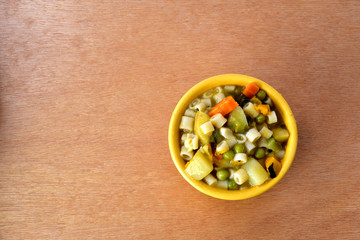 Soup bowl with pasta, beans and vegetables on wood background