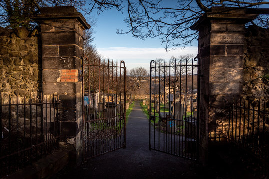 EDINBURGH, SCOTLAND DECEMBER 14, 2018: path to an entrance of a graveyard with a open wrought-iron gate