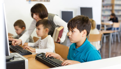 Fototapeta premium Tween boy during lesson in computer room