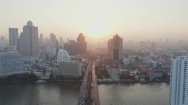 Aerial view over Bangkok city and Chao phraya river and Tak-sin bridge Saphan Taksin BTS train station in the morning with morning sun rise.