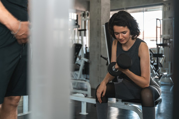 Fototapeta na wymiar young fitness woman execute exercise with exercise-machine in gym.