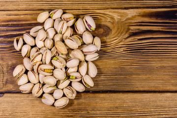 Pile of pistachio nuts on a wooden table