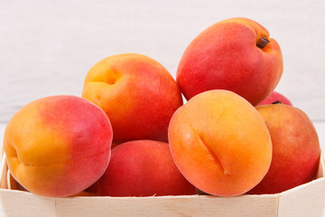 Fototapeta na wymiar Apricot or peach in wooden box as healthy snack or dessert. Food containing vitamins and minerals