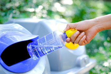 Please dispose of plastic bottle into the tank. A man throw rubbish in the trash can by separate garbage to dispose like hazardous waste ,