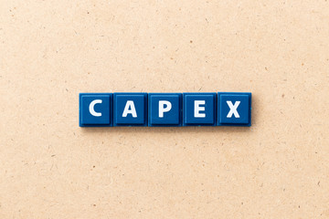 Tile letter in word CAPEX (Abbreviation of Capital Expenditure) on wood background
