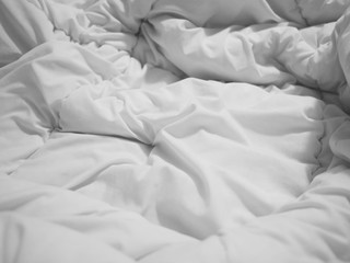 Fototapeta na wymiar crumpled white bedsheet and blanket surface at bedroom.