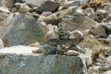 Balanced stone pyramid in mountains with blurry background.