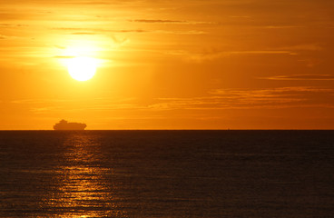 Sonnenuntergang auf dem Ozean mit Frachtcontainer-Schiff