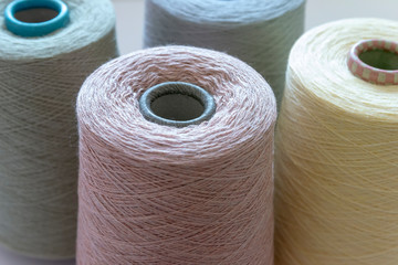 Pastel color bobbins of wool yarn for hand and machine knitting close-up