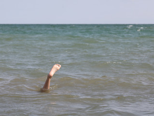 solitary foot in the middle of the sea of the person who is unde