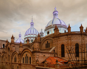 Famous domes of the New Cathedral in Cuenca, Ecuador rise over the city skyline.