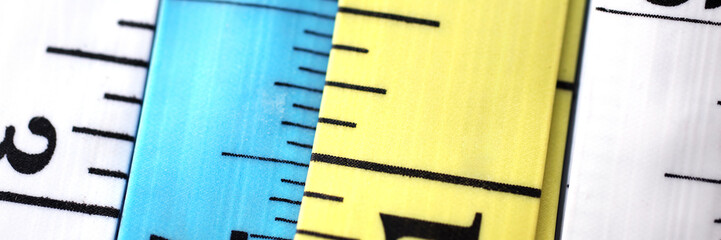Line of colourful tapes arranged by variety of colors closeup. Weight loss dress maker vintage...