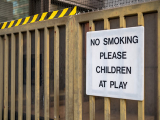 No smoking please, children at play sign on fence at recreational playground area