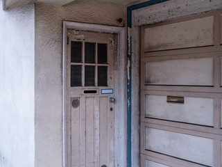 Weathers, dirty, unkempt front door and garage of residential home