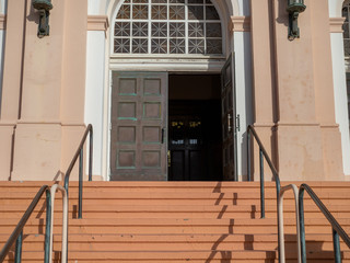 Steps leading into a worn double door entrance of church