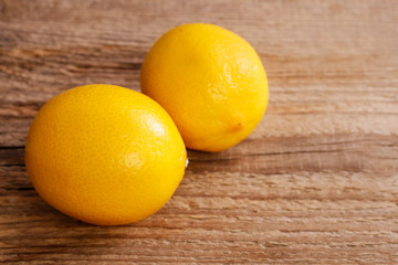 Two lemons on brown wooden table