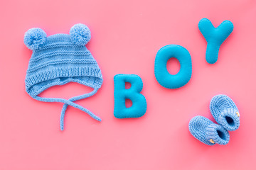 Children's birthday concept. Word boy near booties on pink background top view
