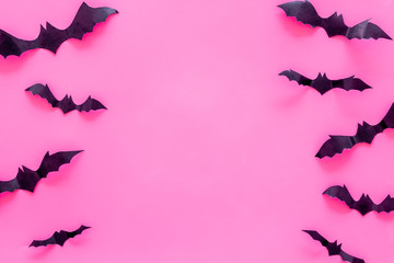 Bats cutout on Halloween frame on pink table top view copy space