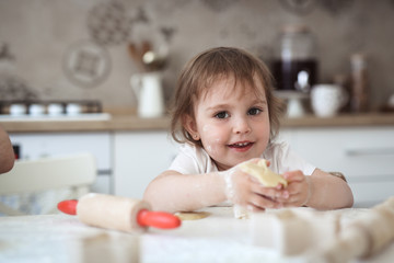 child toddler with dough and rolling pin, kitchen