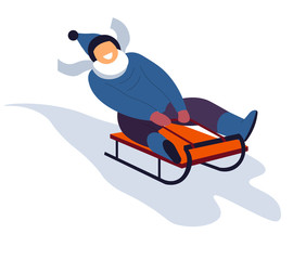 Boy sliding on sled downhill during winter holidays season