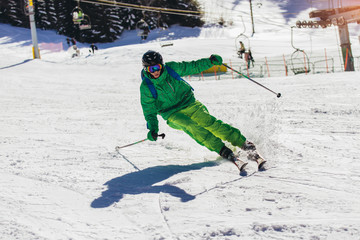 Skier skiing downhill during sunny day in high mountains