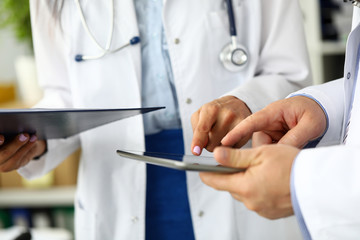 Two doctors looking in tablet pc display solving patient problem closeup concept