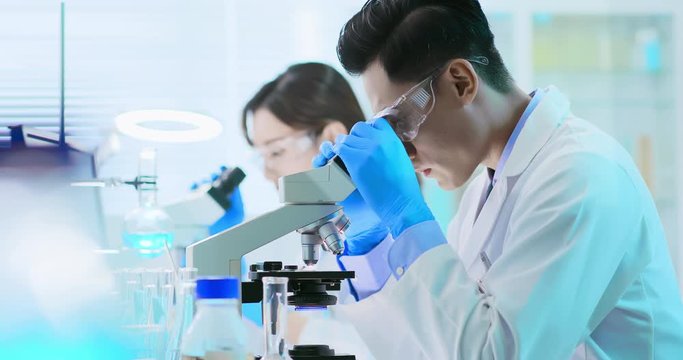 Asian scientist use microscope