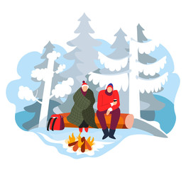 Hikers sitting near campfire in winter forest with camping gear