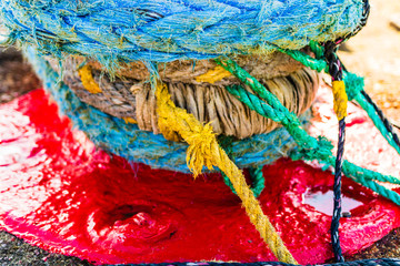 Harbor marina detail. Old rusty mooring bollard with rope. Berth in the passenger port. Mooring...