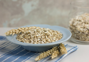 Oat flakes or oatmeal in glass bottle on rustic wood table. 