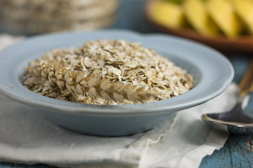 Oat flakes or oatmeal in glass bottle on rustic wood table. 