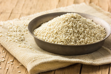 Sesame seeds in a  bowl on wooden table