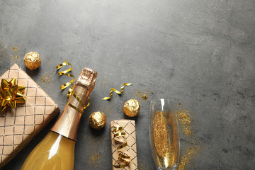 Flat lay composition with bottle of champagne for celebration on grey stone background. Space for text