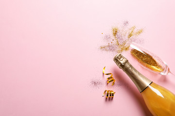 Flat lay composition with bottle of champagne for celebration on pink background. Space for text