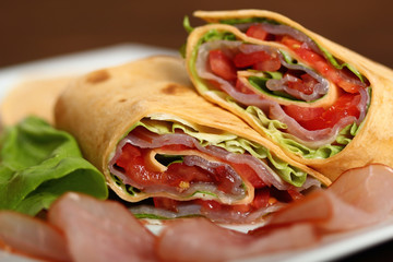 Wrap tortilla sandwich with ham, tomato, lettuce.
