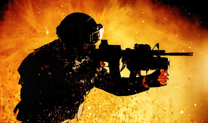 Soldier with rifle shooting on fiery background
