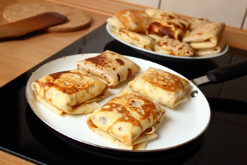 Frying pancakes with fillings. Traditional russian pancakes (blini) with curd. Cheese blintzes.