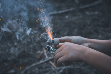 Hands are playing a smoke bomb in a Thai festival.