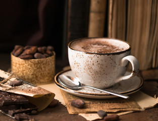 Hot chocolate - winter spicy drink in a brown cup on  wooden background.